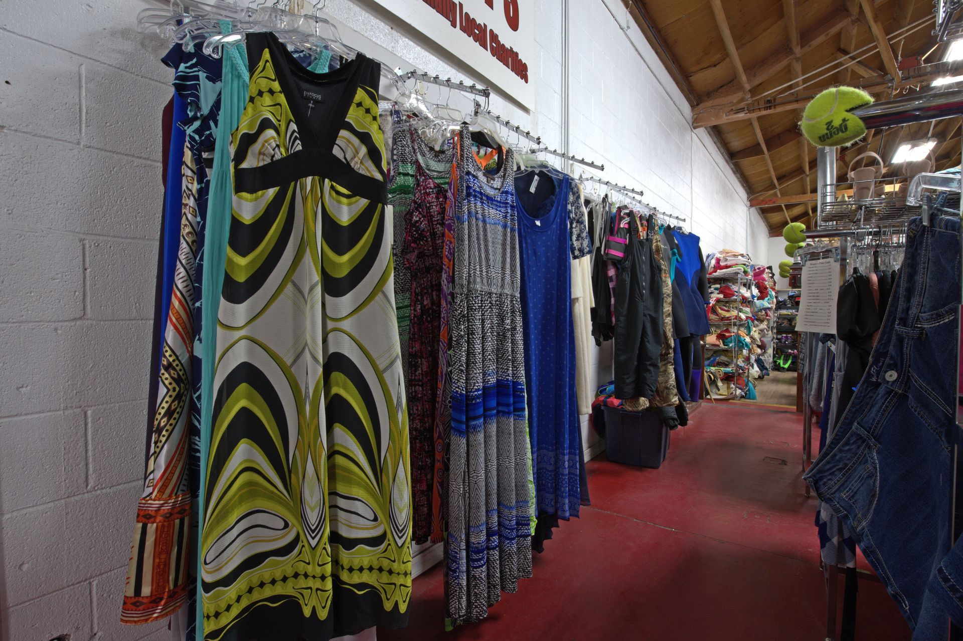A row of clothes hanging on racks in a store