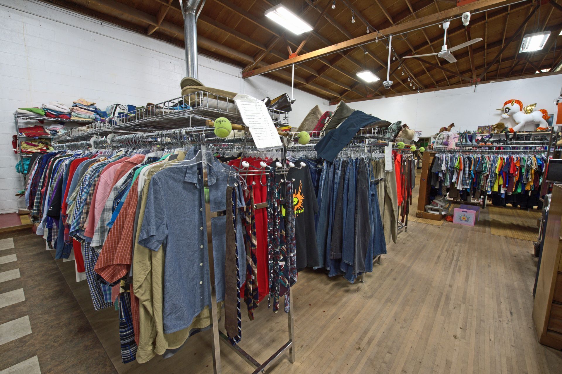 A store filled with lots of clothes hanging on racks.