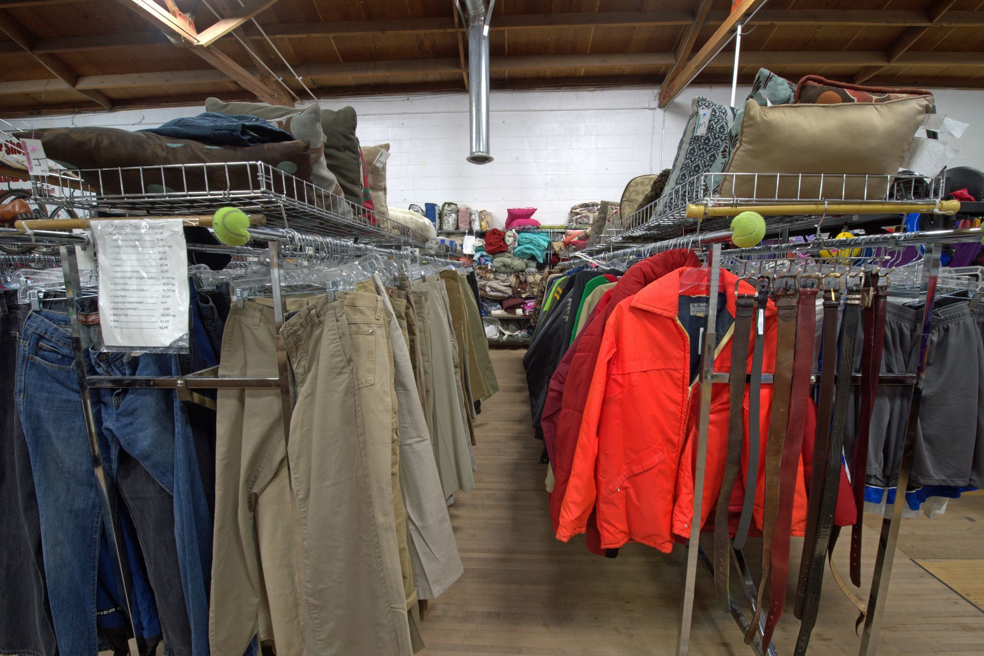 A bunch of clothes are hanging on racks in a store