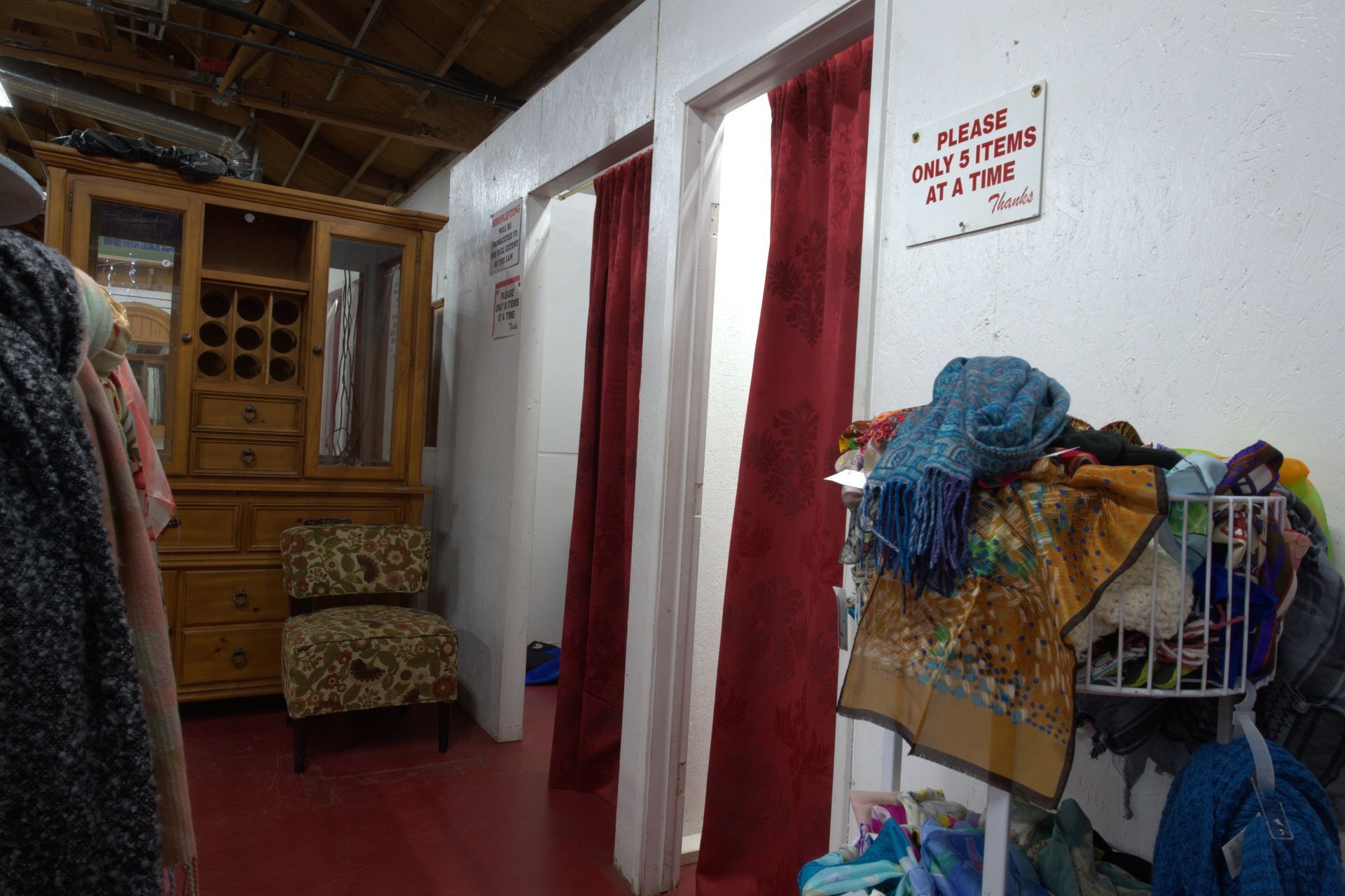 A dressing room with red curtains and a sign on the wall.