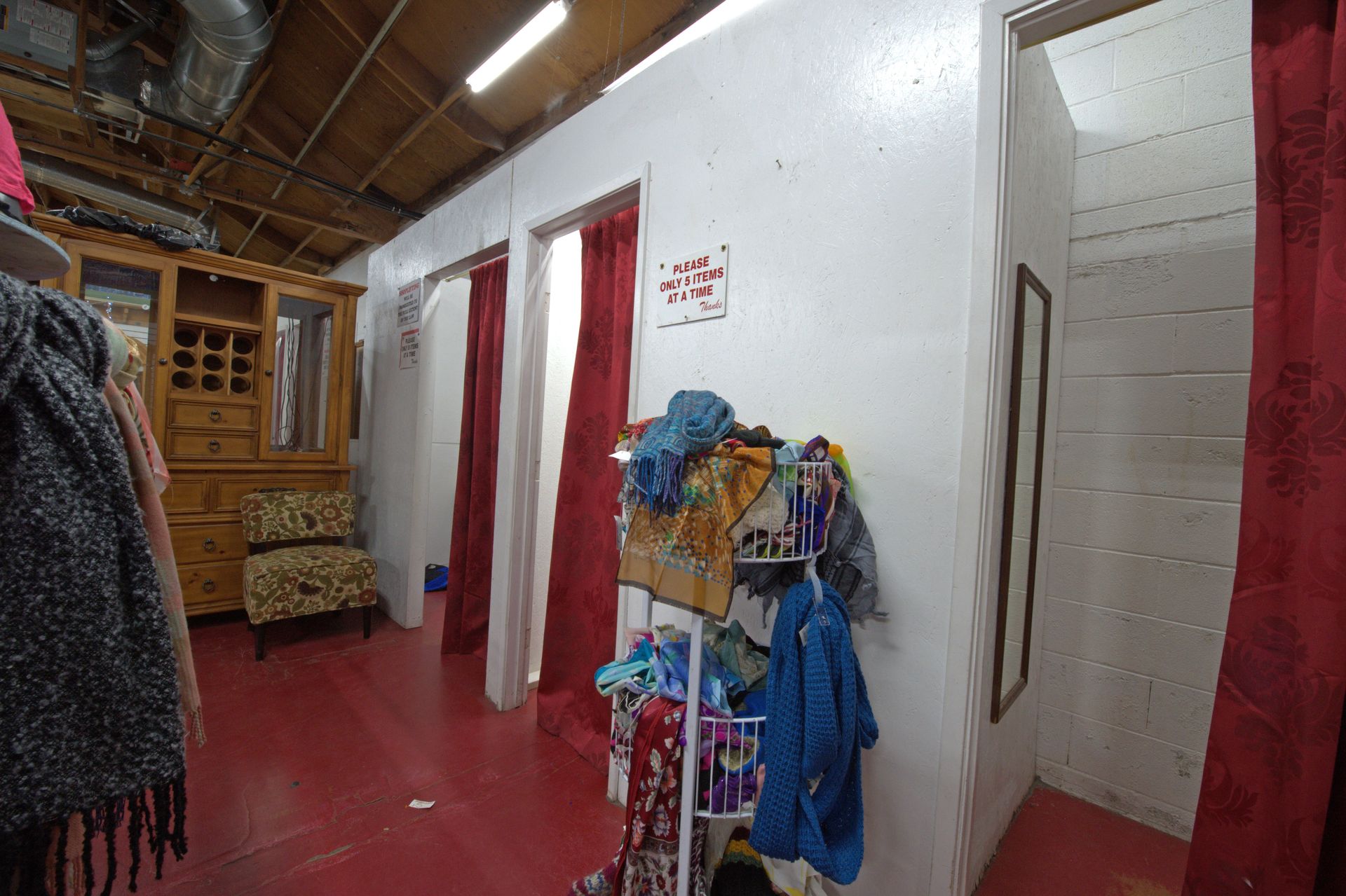 A woman is standing in a dressing room in a store.
