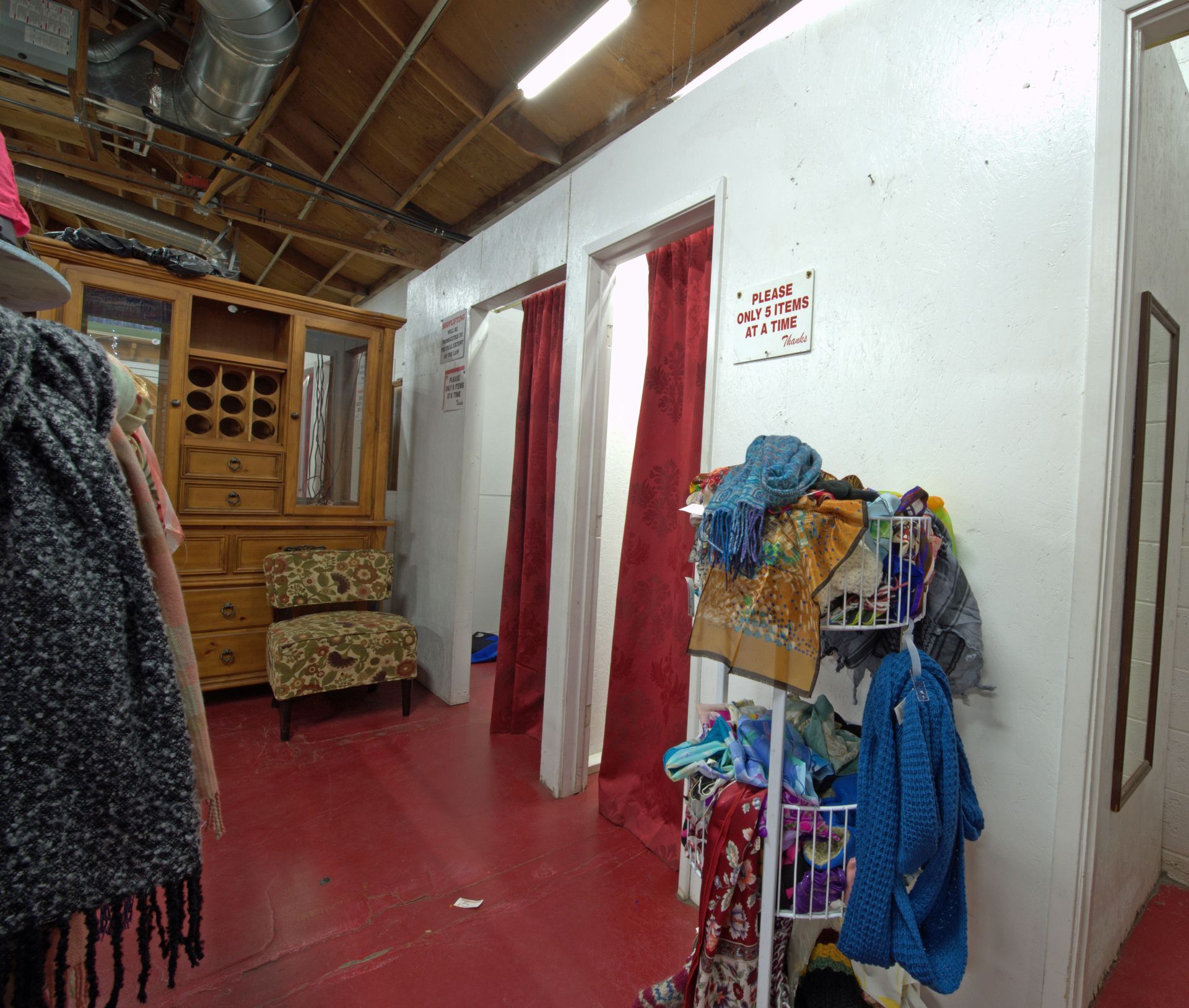 A dressing room with red curtains and a sign that says no waiting time