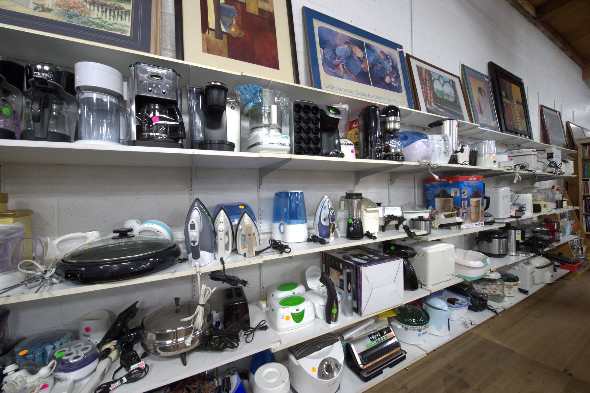 A store filled with lots of appliances and pictures on shelves.
