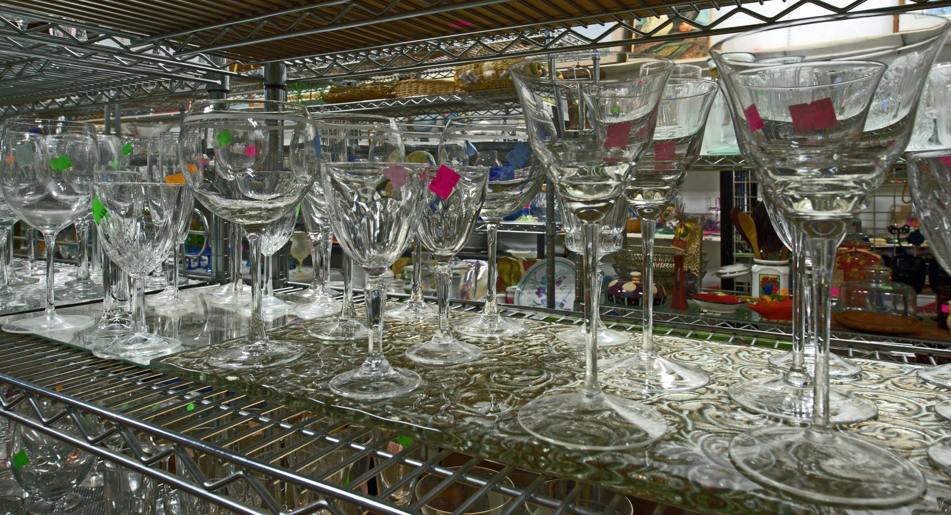 A bunch of wine glasses are lined up on a shelf