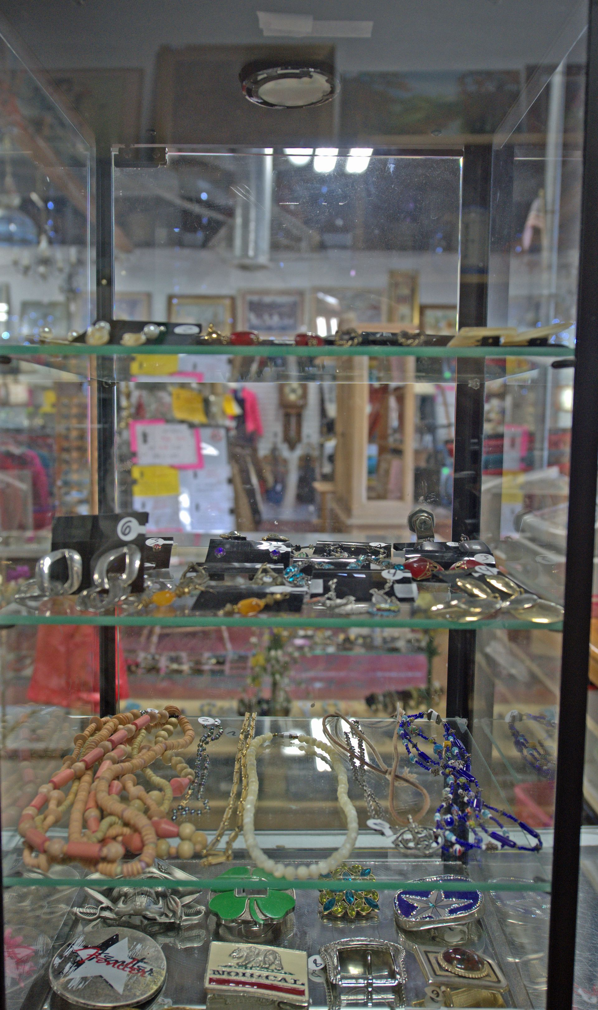 A glass display case filled with lots of jewelry in a store.