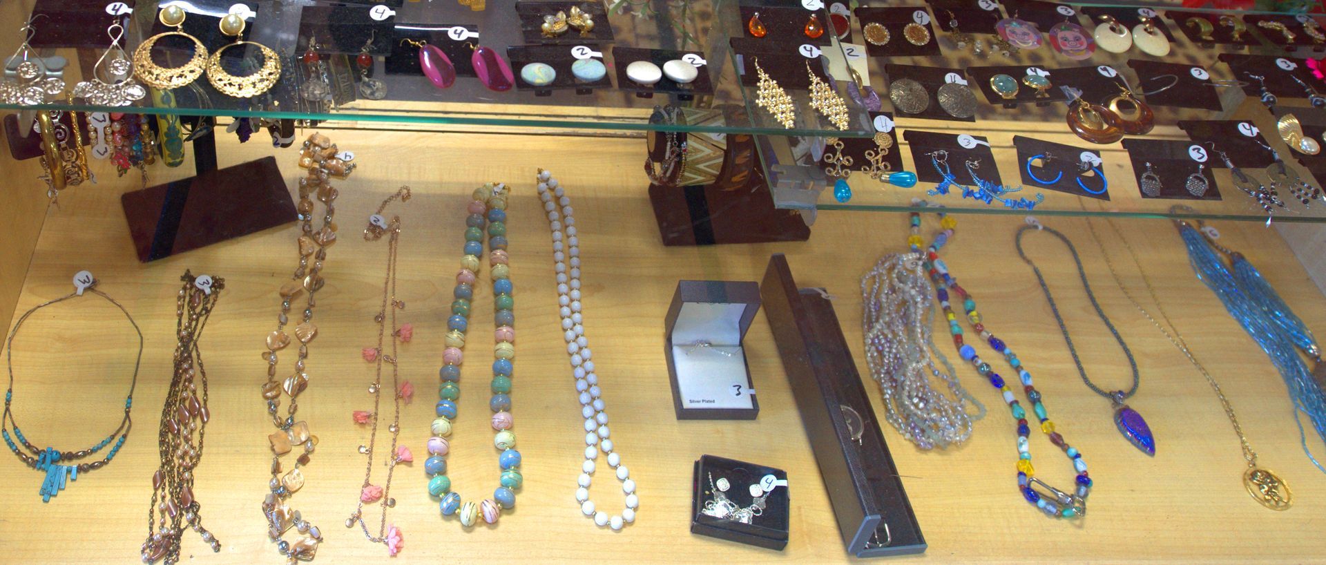 A display case filled with lots of necklaces and earrings