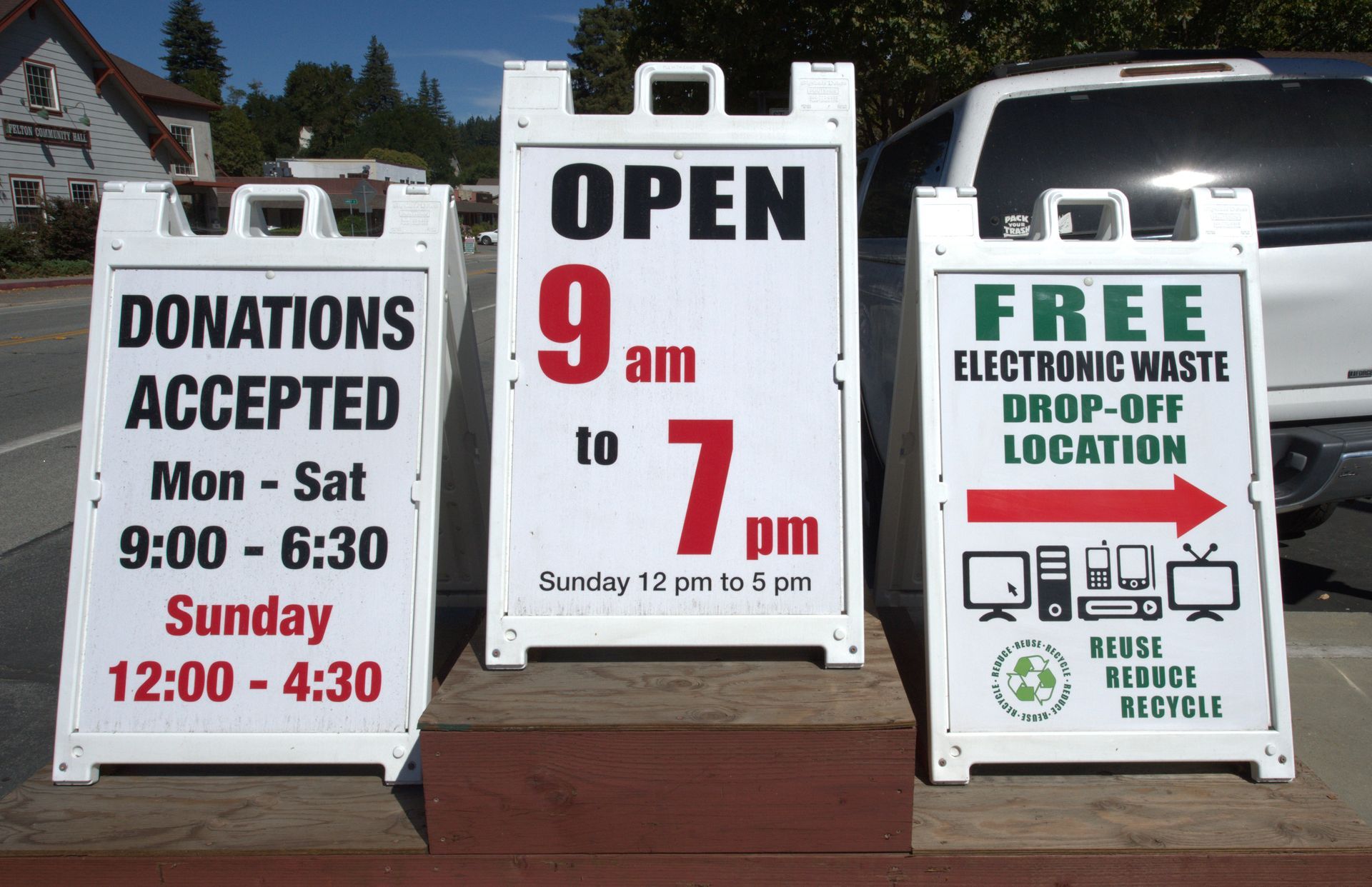 A donations accepted sign is next to a free electronic waste drop-off location sign