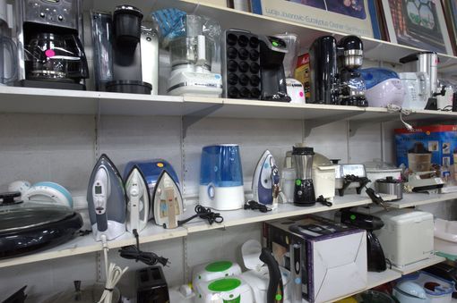 There are many different types of appliances on the shelves.