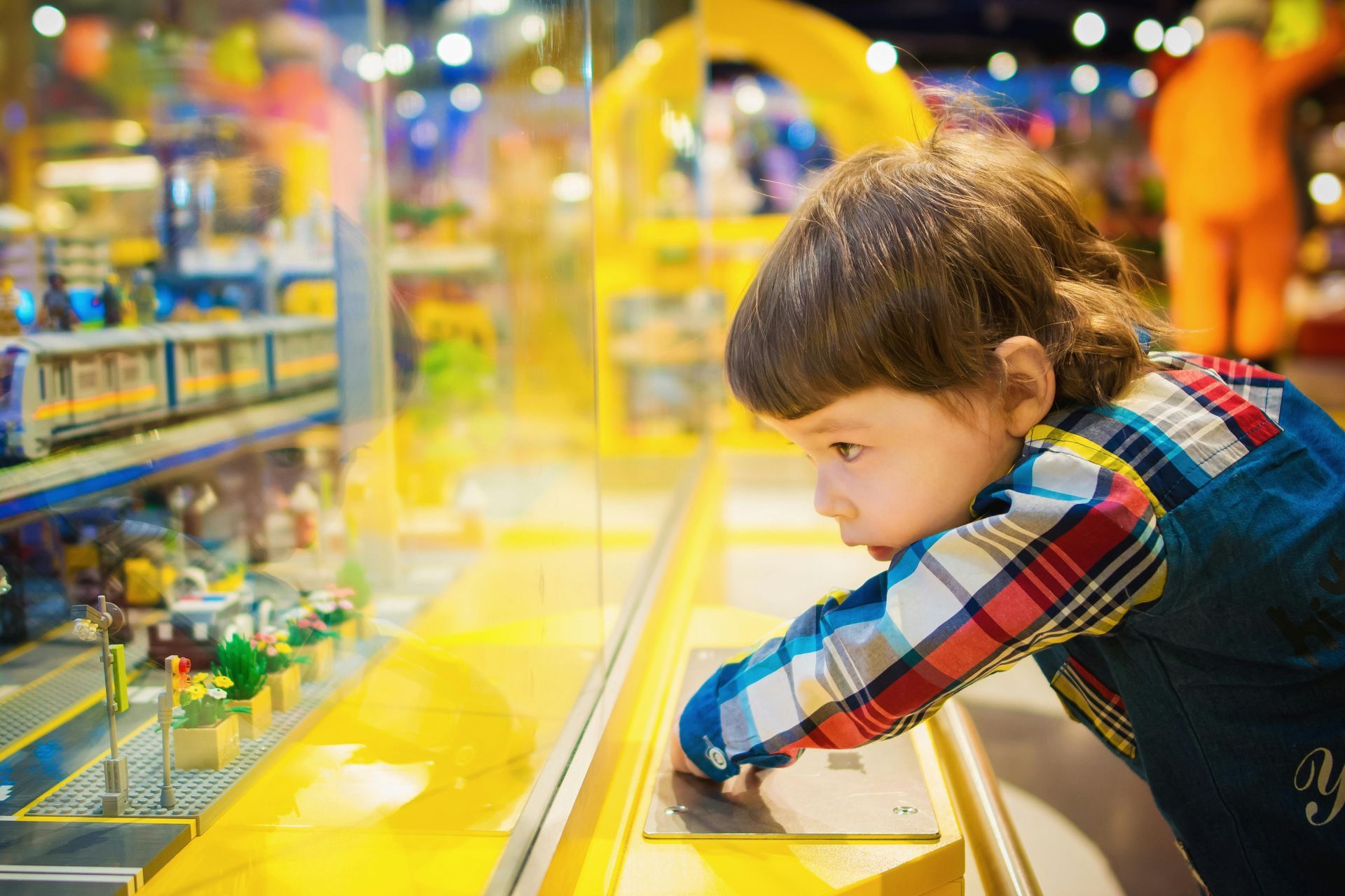 A little boy is looking at toys in a toy store.