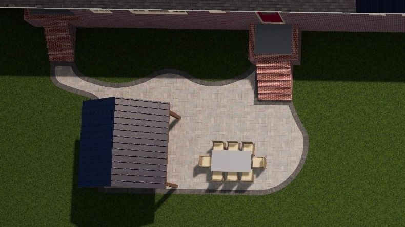 Overhead view of a patio with table and chairs, adjacent to a grassy yard and a building with brick steps and a dark-roofed structure.