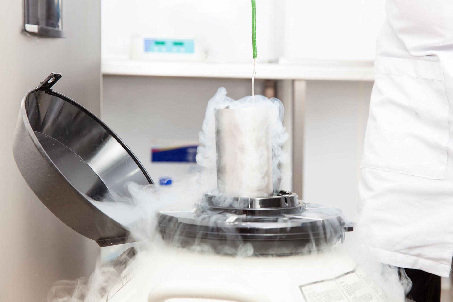 Une personne versant de l’azote liquide dans un récipient, créant un nuage brumeux.