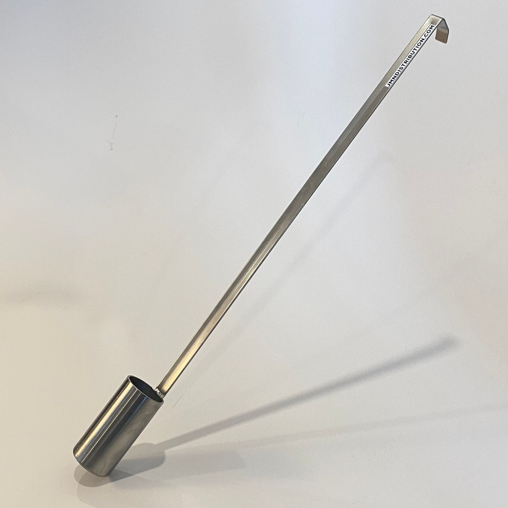 Metal soil sampler tool on a white background. Cylinder on one end, handle on the other.