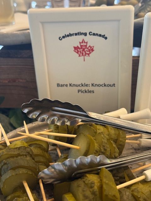 Pickles on skewers, labeled 