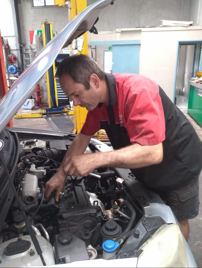 A Man Is Working Under The Hood Of A Car — Headland Auto Servicing & Air Conditioning In Alexandra Headland, QLD
