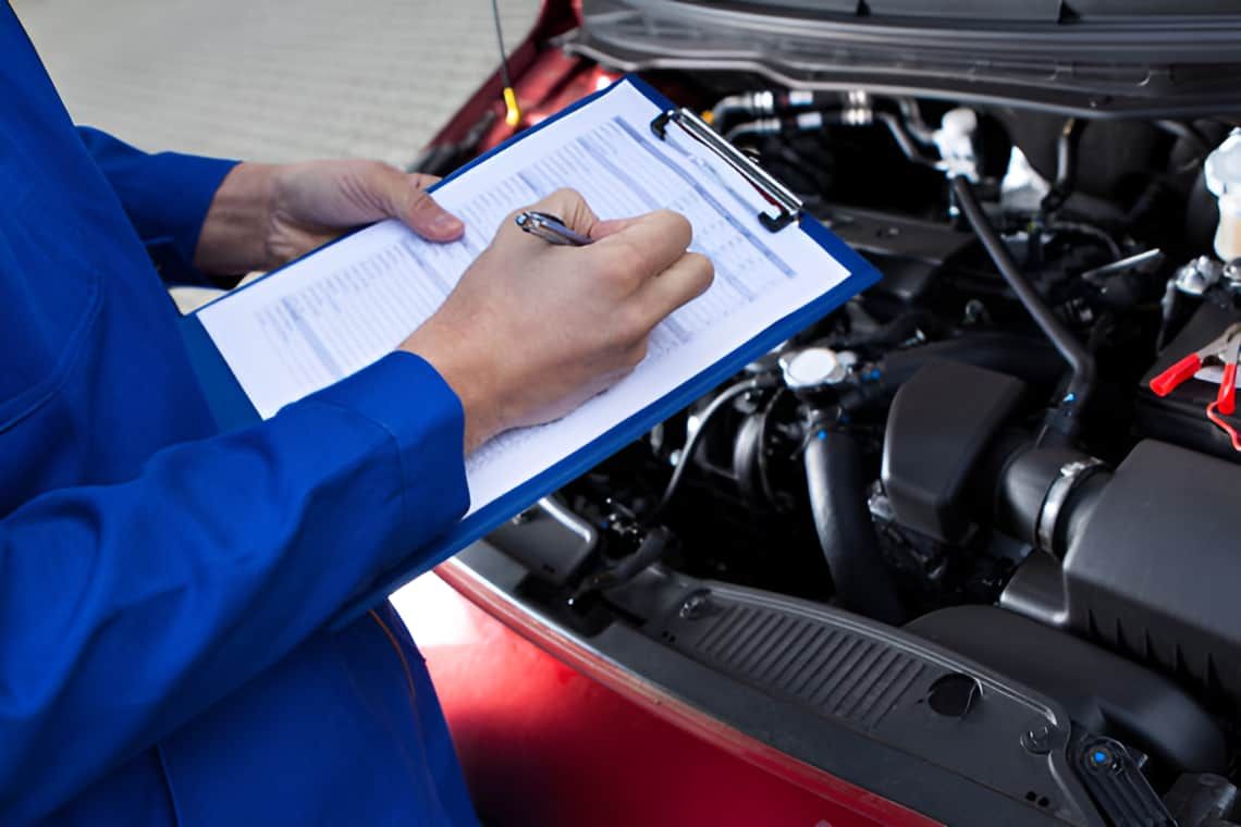 A Mechanic Is Writing On A Clipboard — Headland Auto Servicing & Air Conditioning In Alexandra Headland, QLD