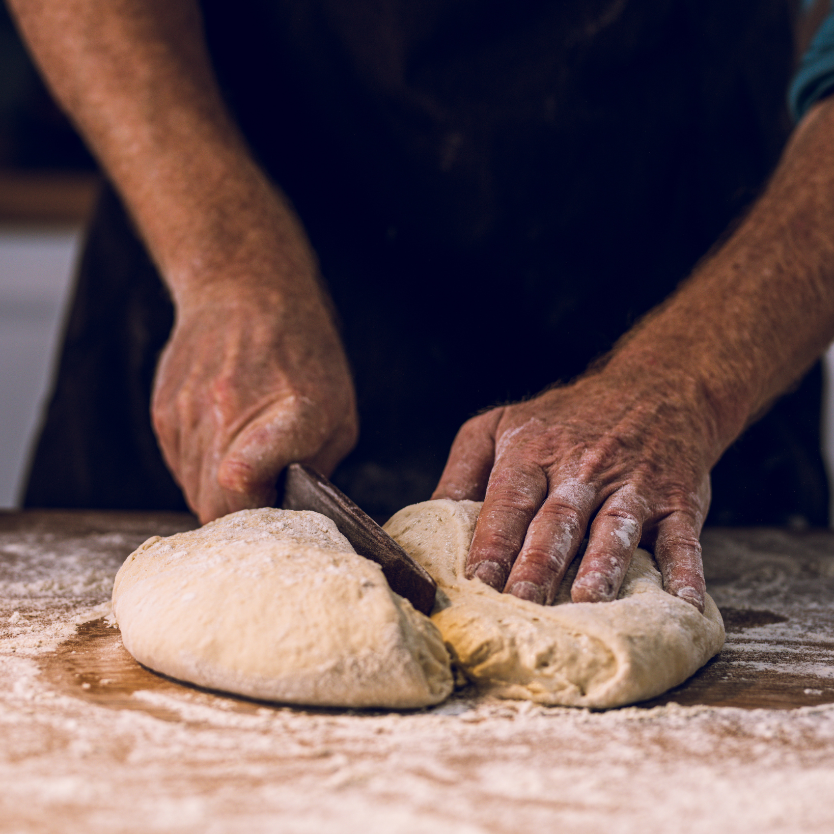 Bread baking on a carbon steel plate with flames in the background.