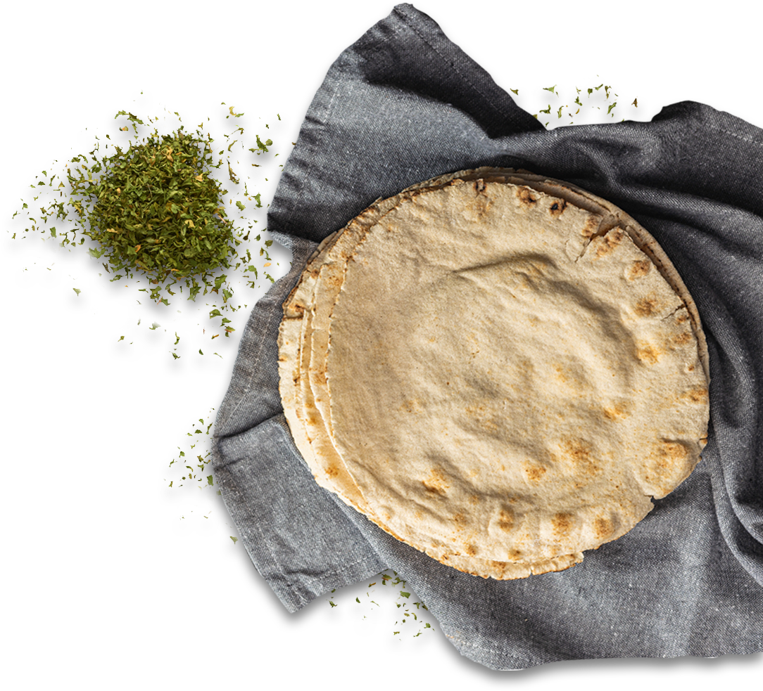 flat bread on a grey cloth with herbs