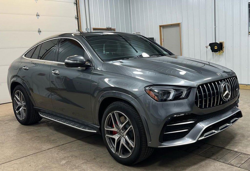 Gray Mercedes-AMG SUV coupe, front view, inside a garage.