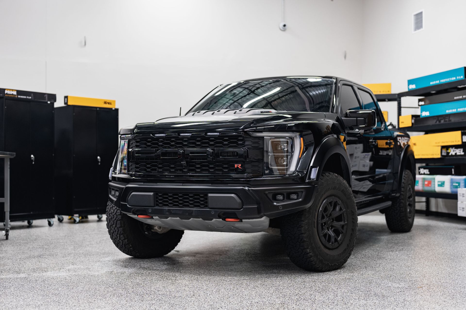 A black ford raptor is parked in a garage.