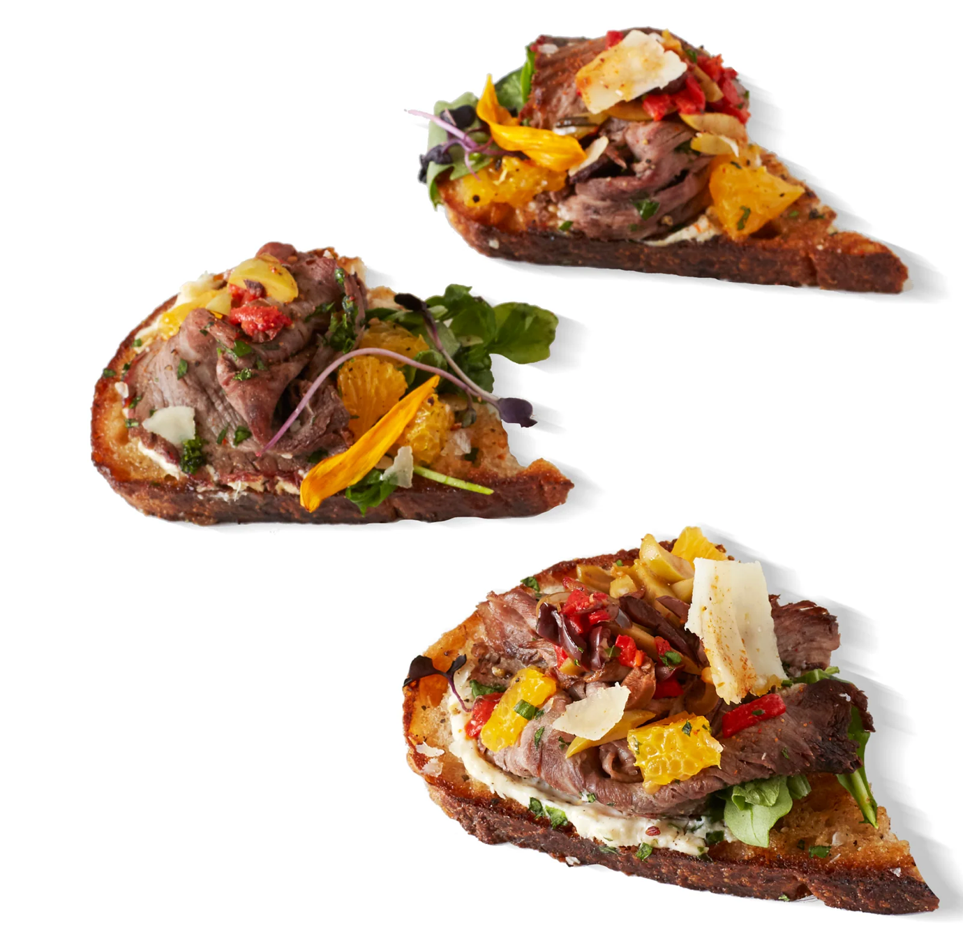 Three slices of bread with meat and vegetables on them