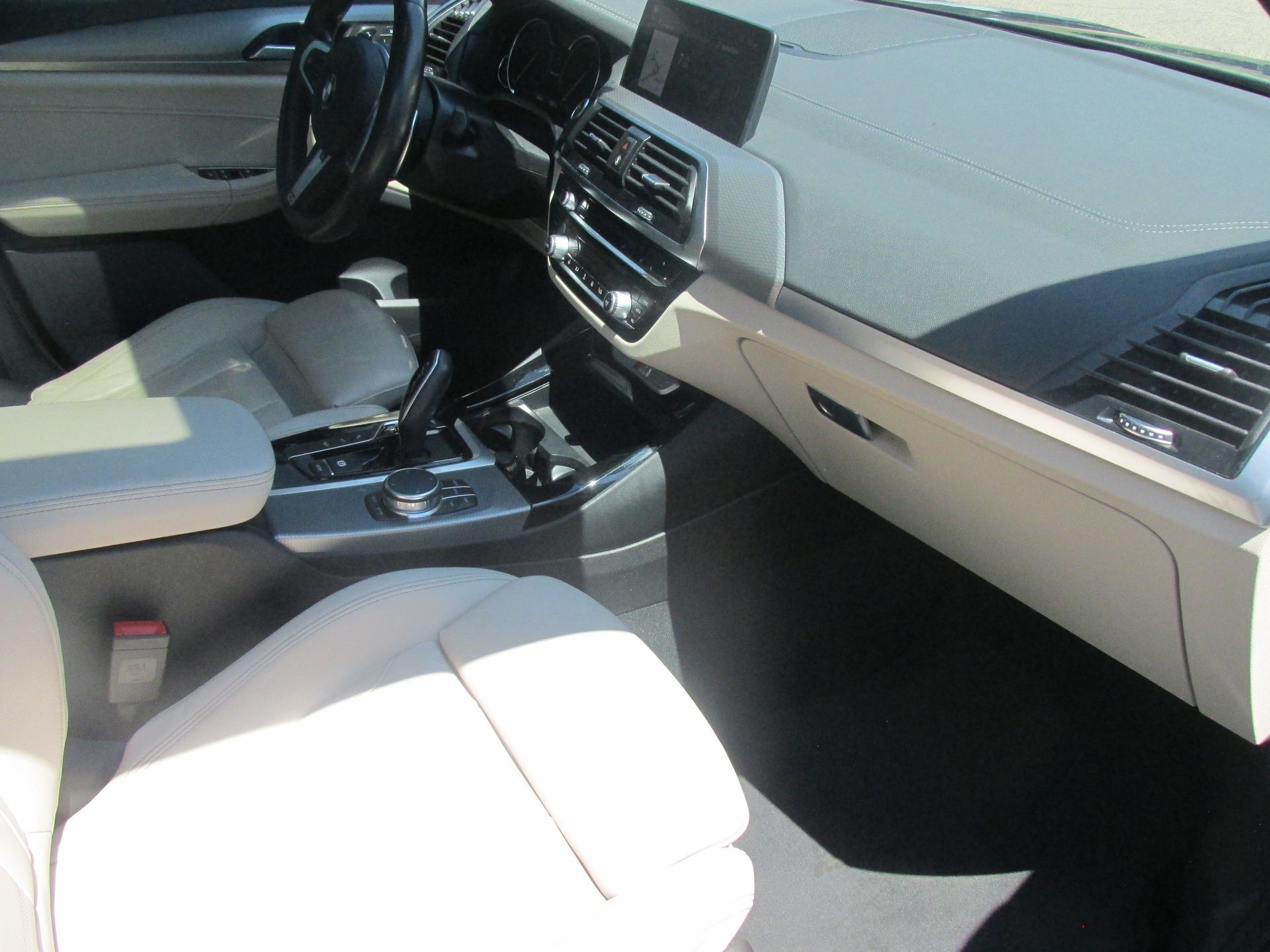 The interior of a car with white seats and a steering wheel