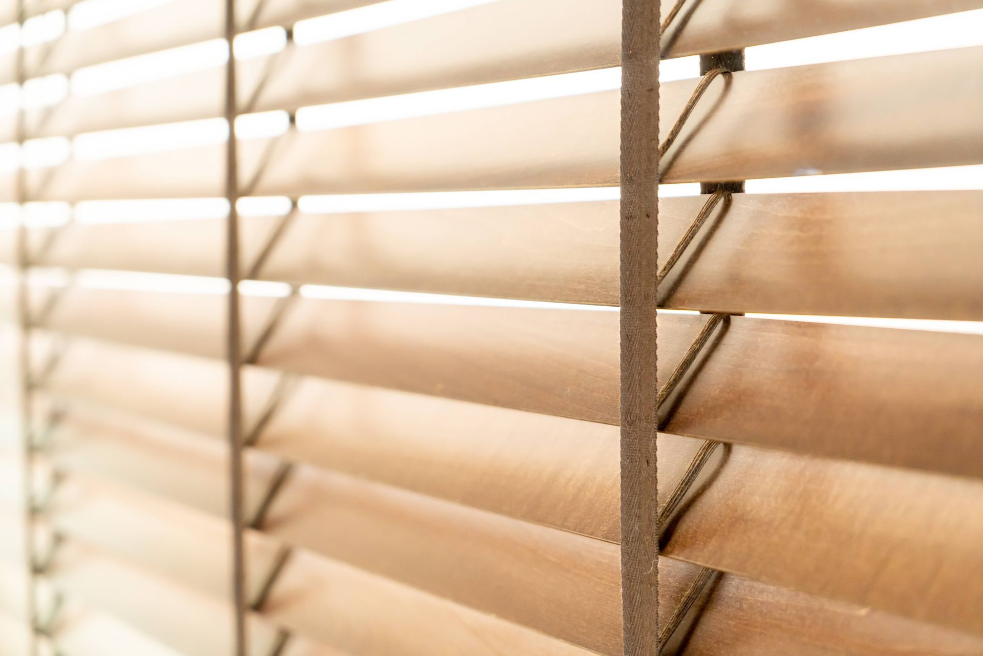 A set of wooden blinds with light streaming through at The Blind Guy near Kalispell, MT
