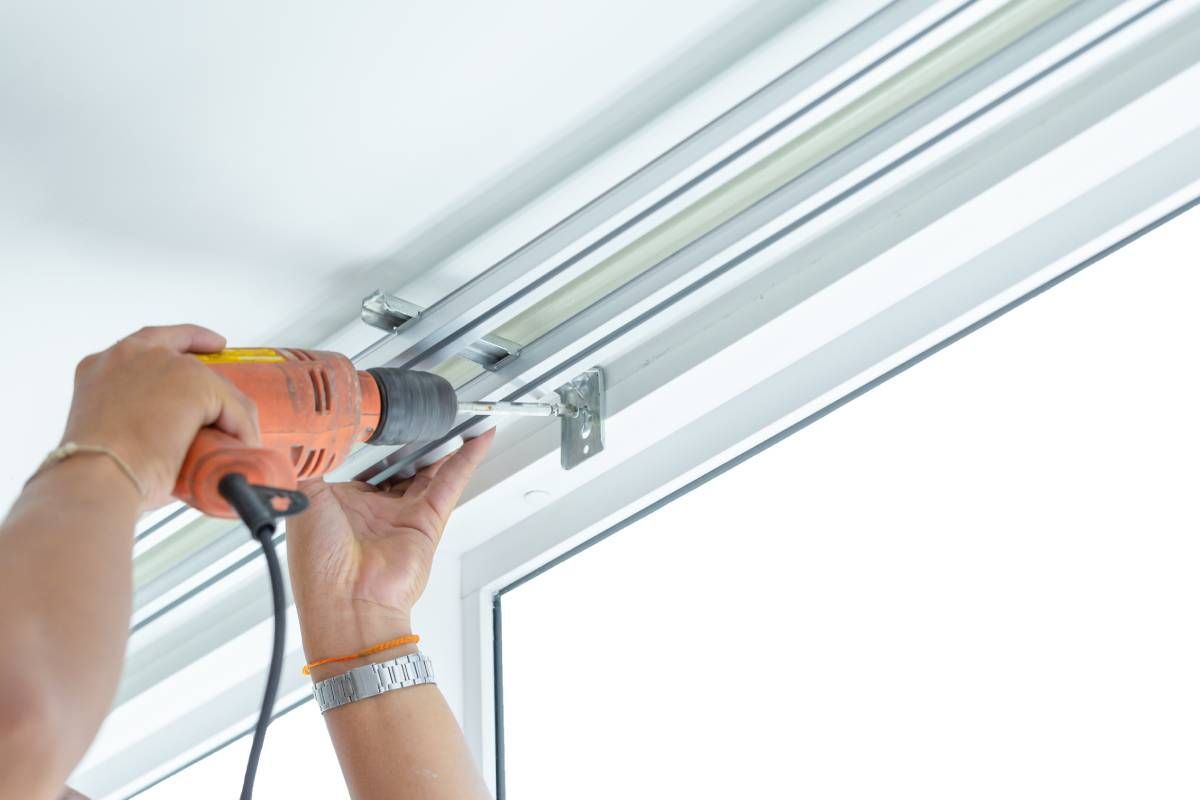 A professional installing a mount above a sliding glass door for window treatments at The Blind Guy Kalispell near Flathead Valley, Montana (MT)