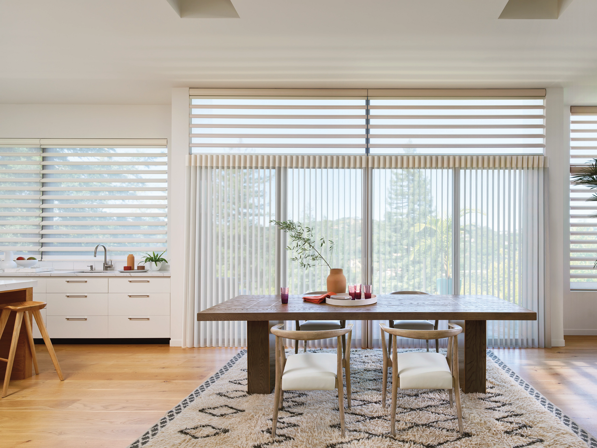 Vertical and horizontal blinds in an open-plan kitchen and dining room.