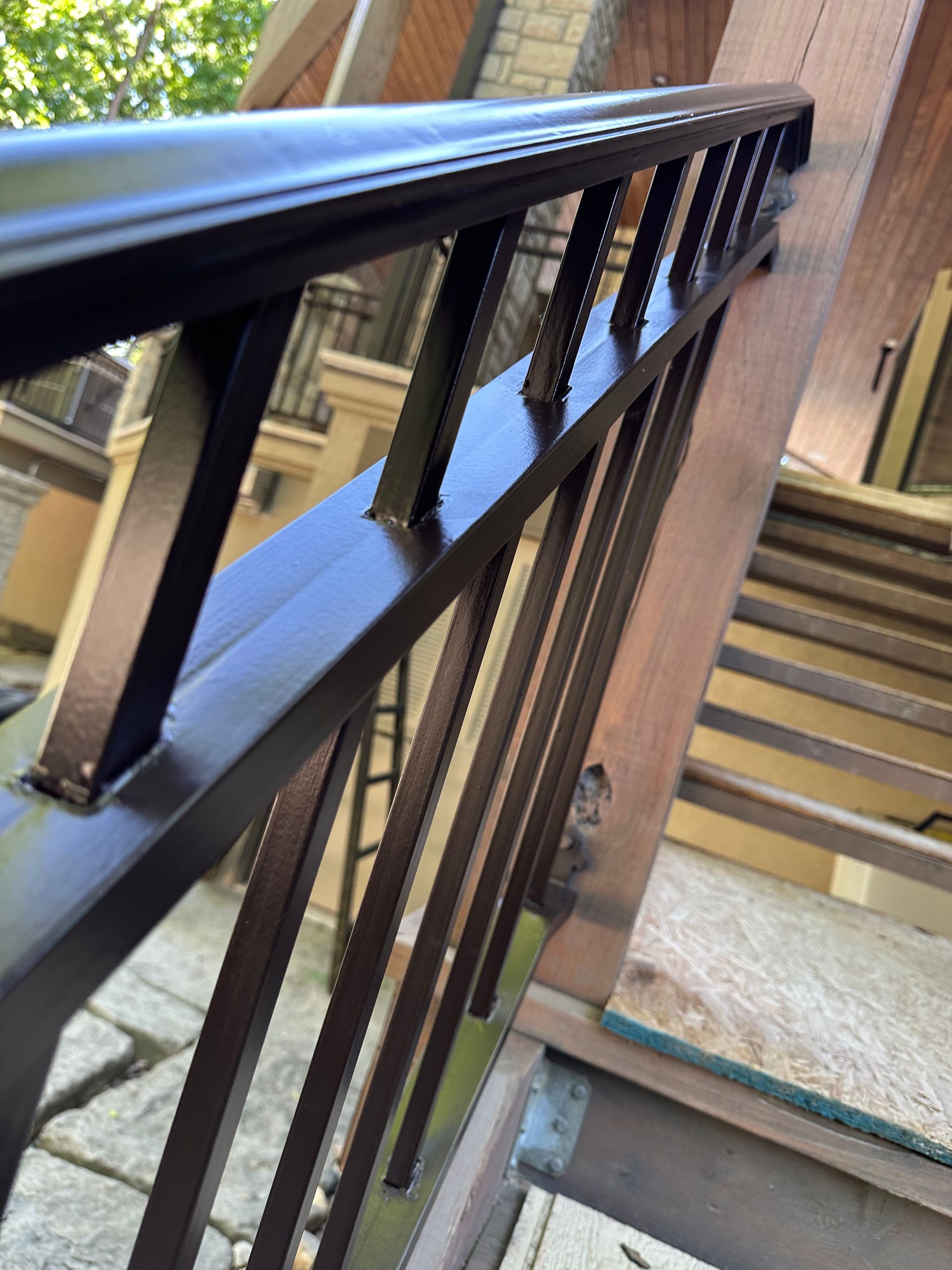 Brown metal railing on wooden steps.