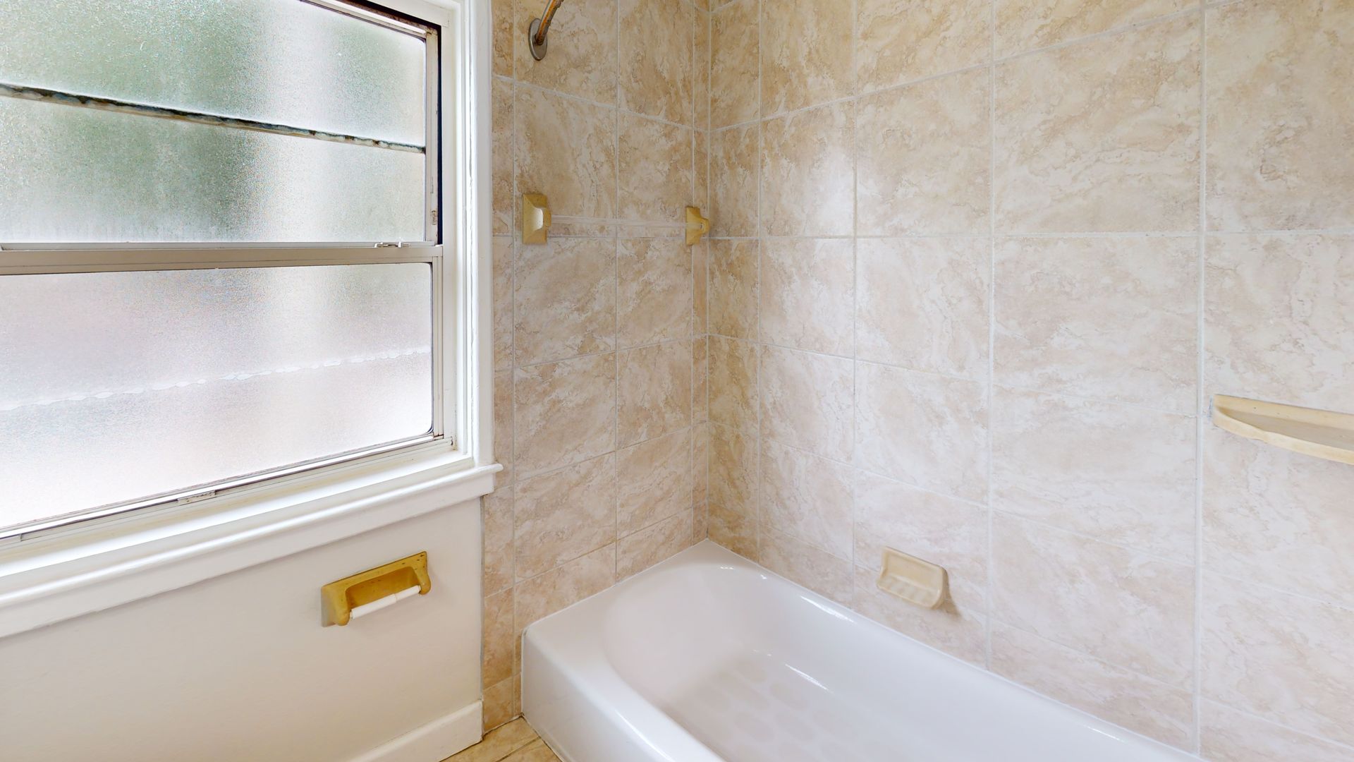 A bathroom with a bathtub and a window.
