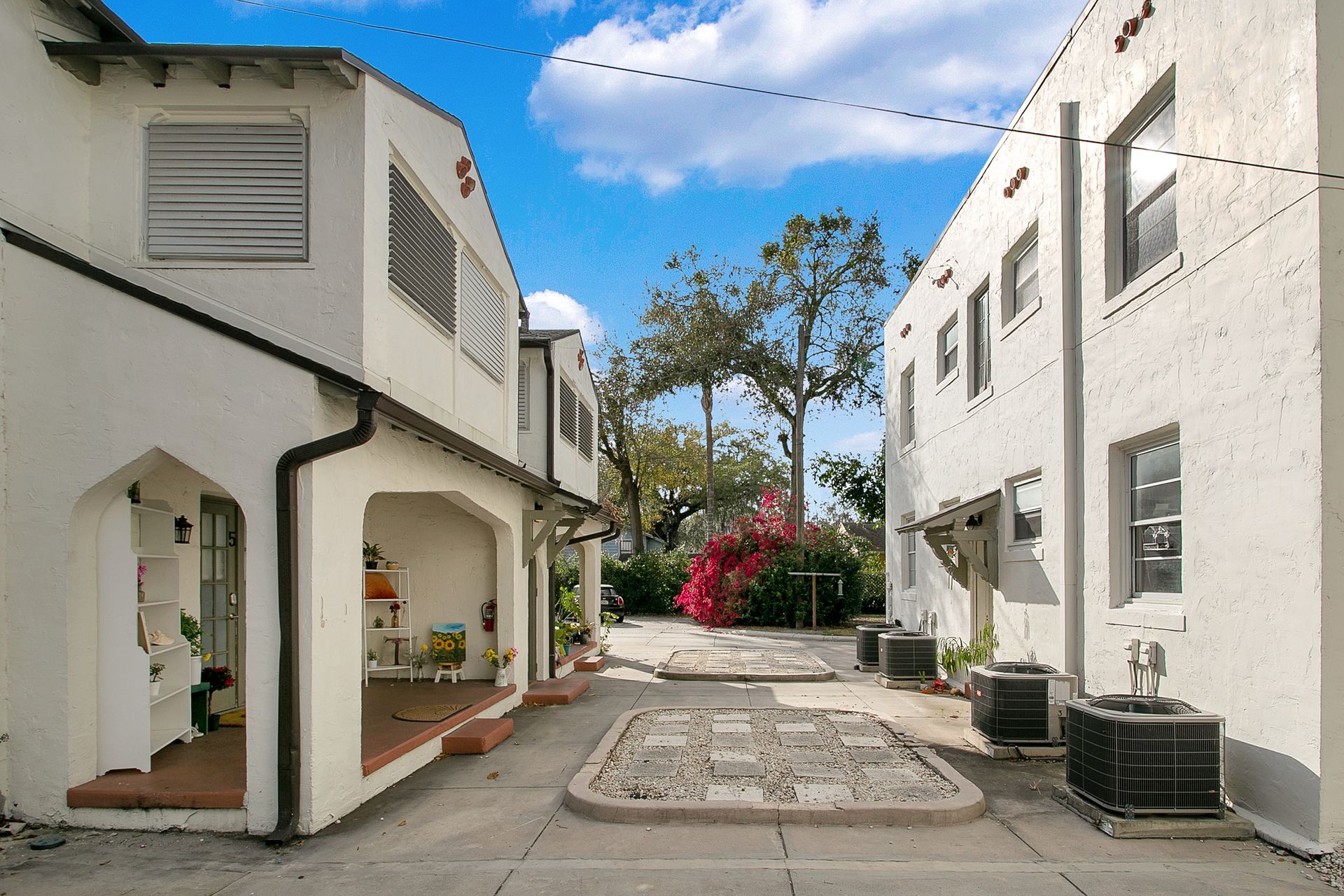 A row of white buildings with a courtyard between them.