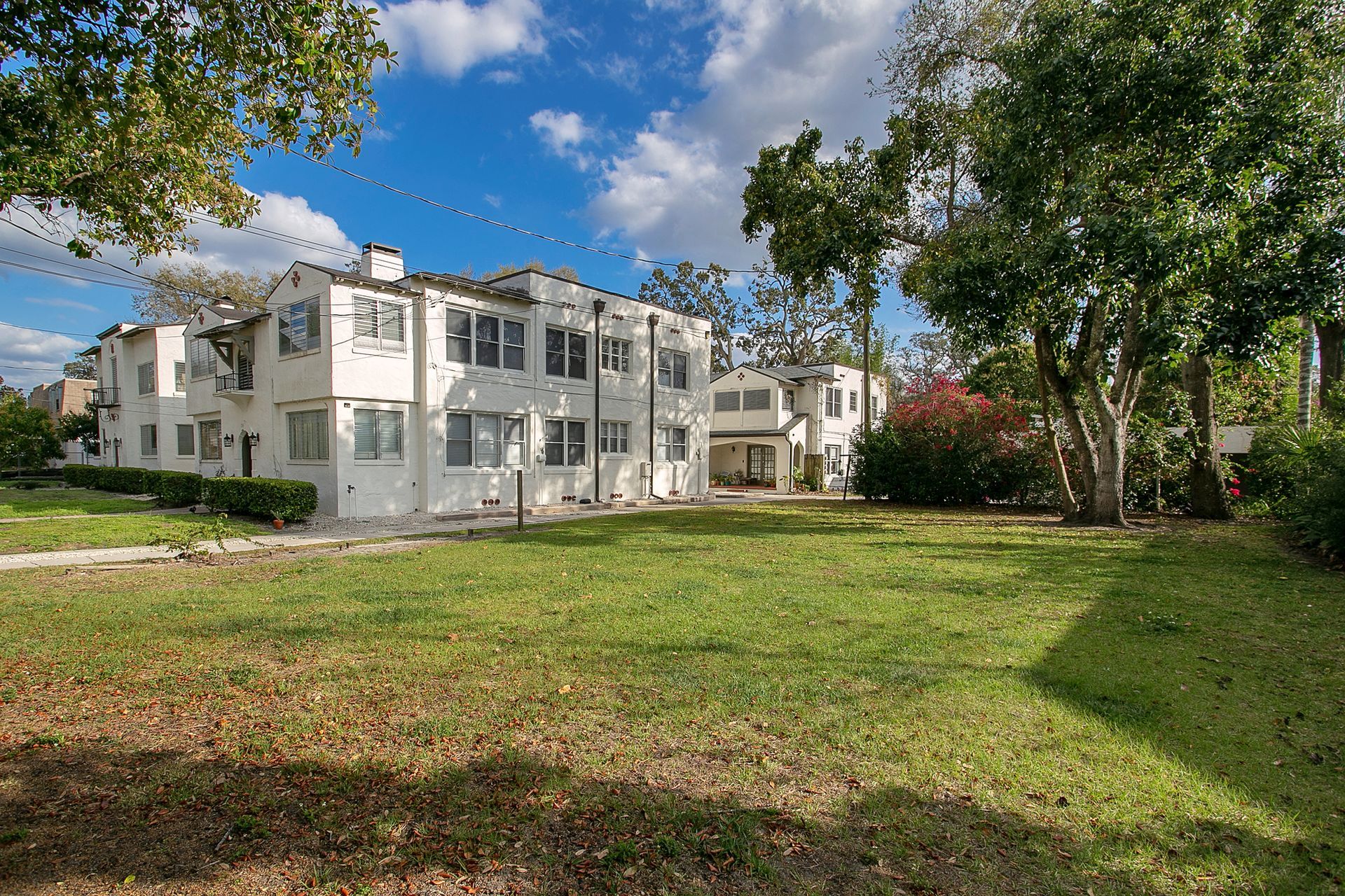 A large white building with a large grassy area in front of it.