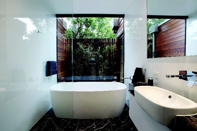 A Bathroom With a Tub, Sink, Mirror and Window — Leemark Design Services In Parramatta Park, QLD