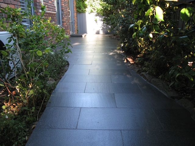 A Walkway With a Brick Building in the Background — Leemark Design Services In Parramatta Park, QLD