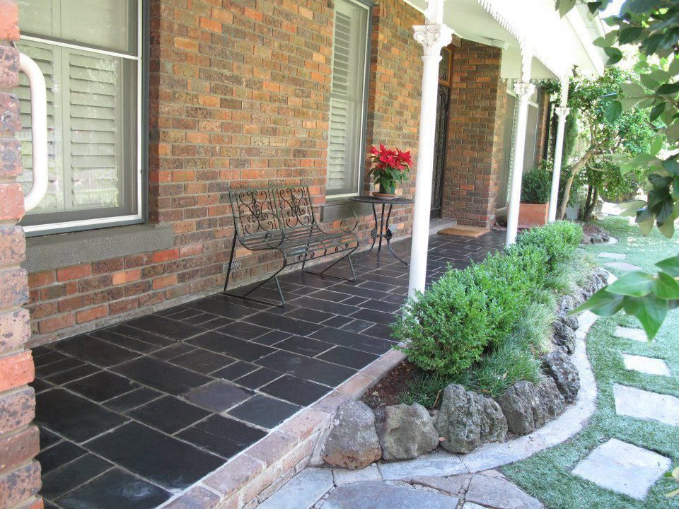 A Brick House With A Porch And A Bench — Leemark Design Services In Parramatta Park, QLD