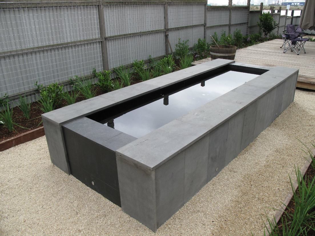 A Large Concrete Pond In A Backyard With A Fence In The Background — Leemark Design Services In Parramatta Park, QLD