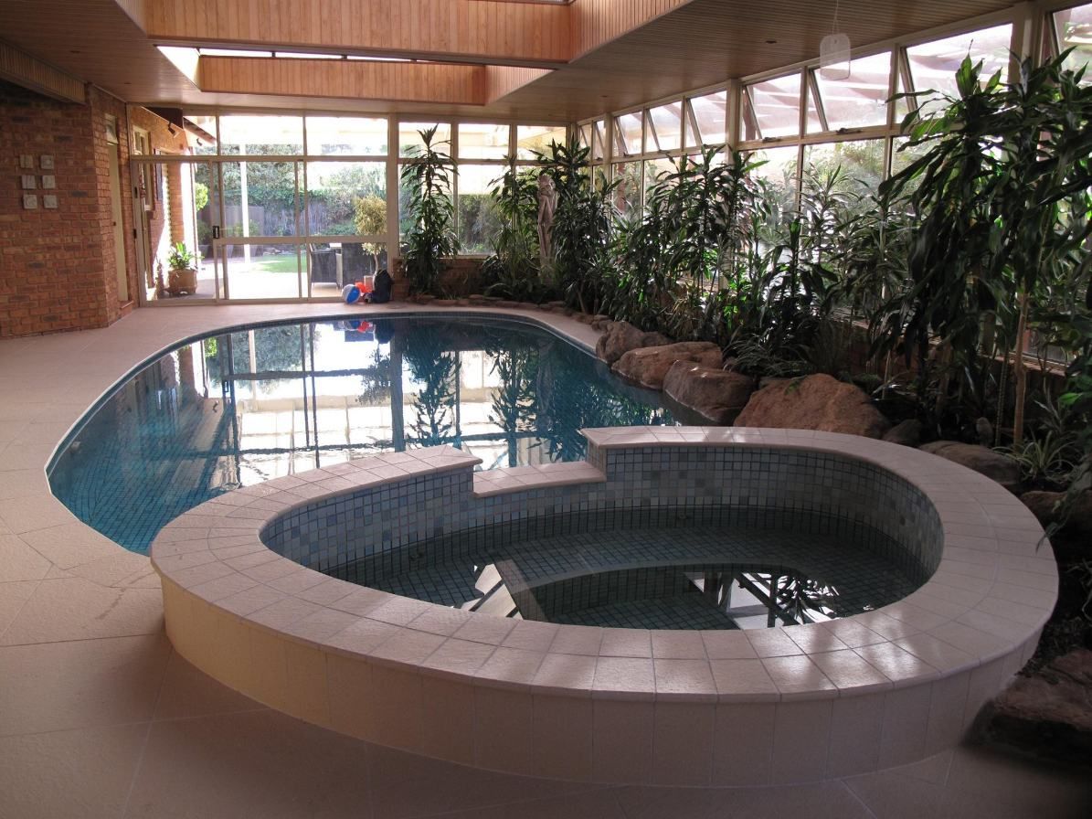 A Large Indoor Swimming Pool With a Hot Tub in the Middle — Leemark Design Services In Parramatta Park, QLD