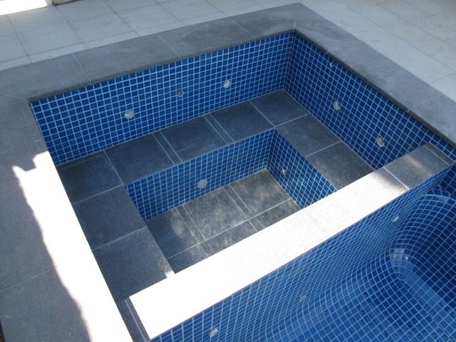A Swimming Pool With Blue Tiles and Stairs — Leemark Design Services In Parramatta Park, QLD