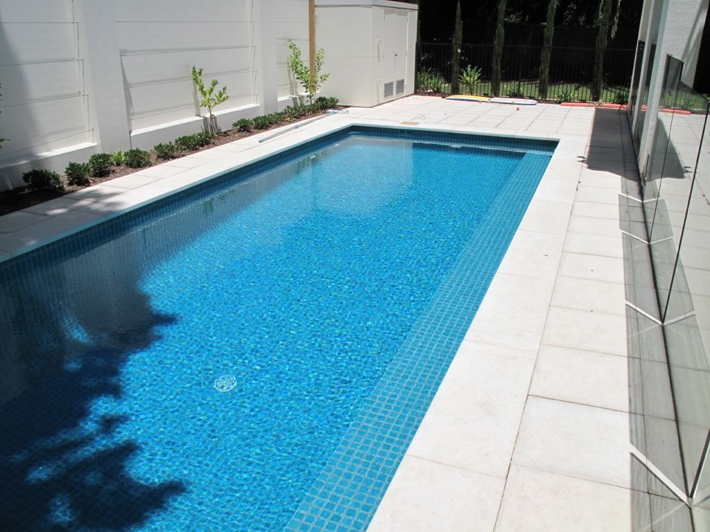A Large Swimming Pool With a White Fence Surrounding It — Leemark Design Services In Parramatta Park, QLD