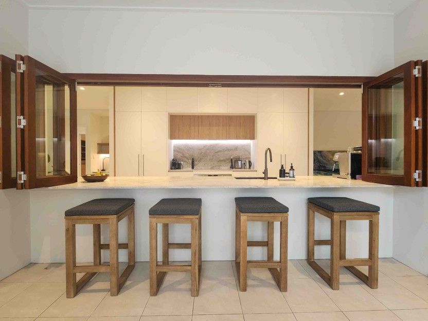 A Kitchen With Four Wooden Stools and a Large Island — Leemark Design Services In Parramatta Park, QLD