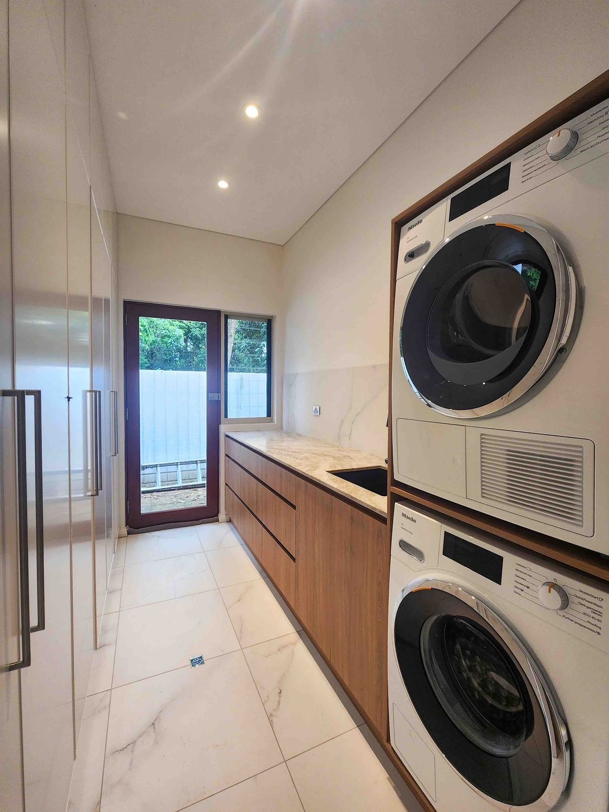 A Laundry Room With a Washer and Dryer Stacked on Top of Each Other — Leemark Design Services In Parramatta Park, QLD
