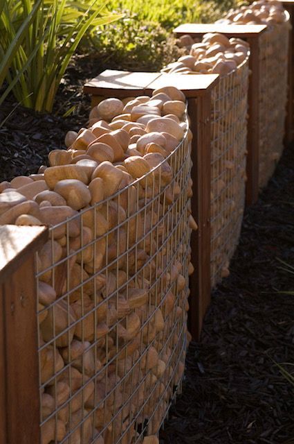A Fence Made of Rocks and a Wooden Post — Leemark Design Services In Parramatta Park, QLD