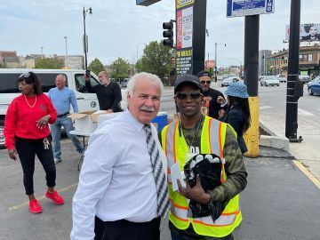 Two men smiling for the camera outdoors.