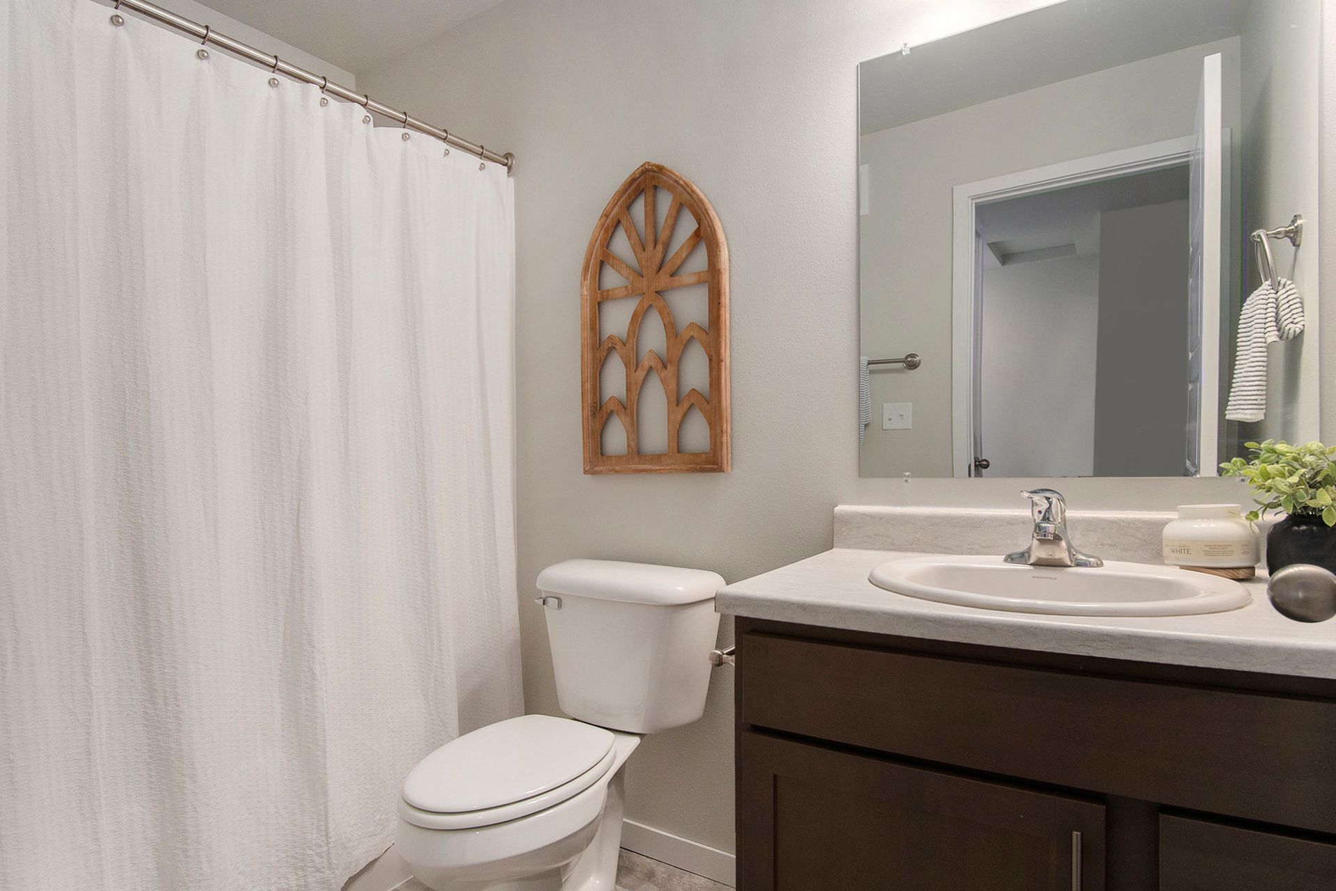Bathroom with toilet, shower, and sink.
