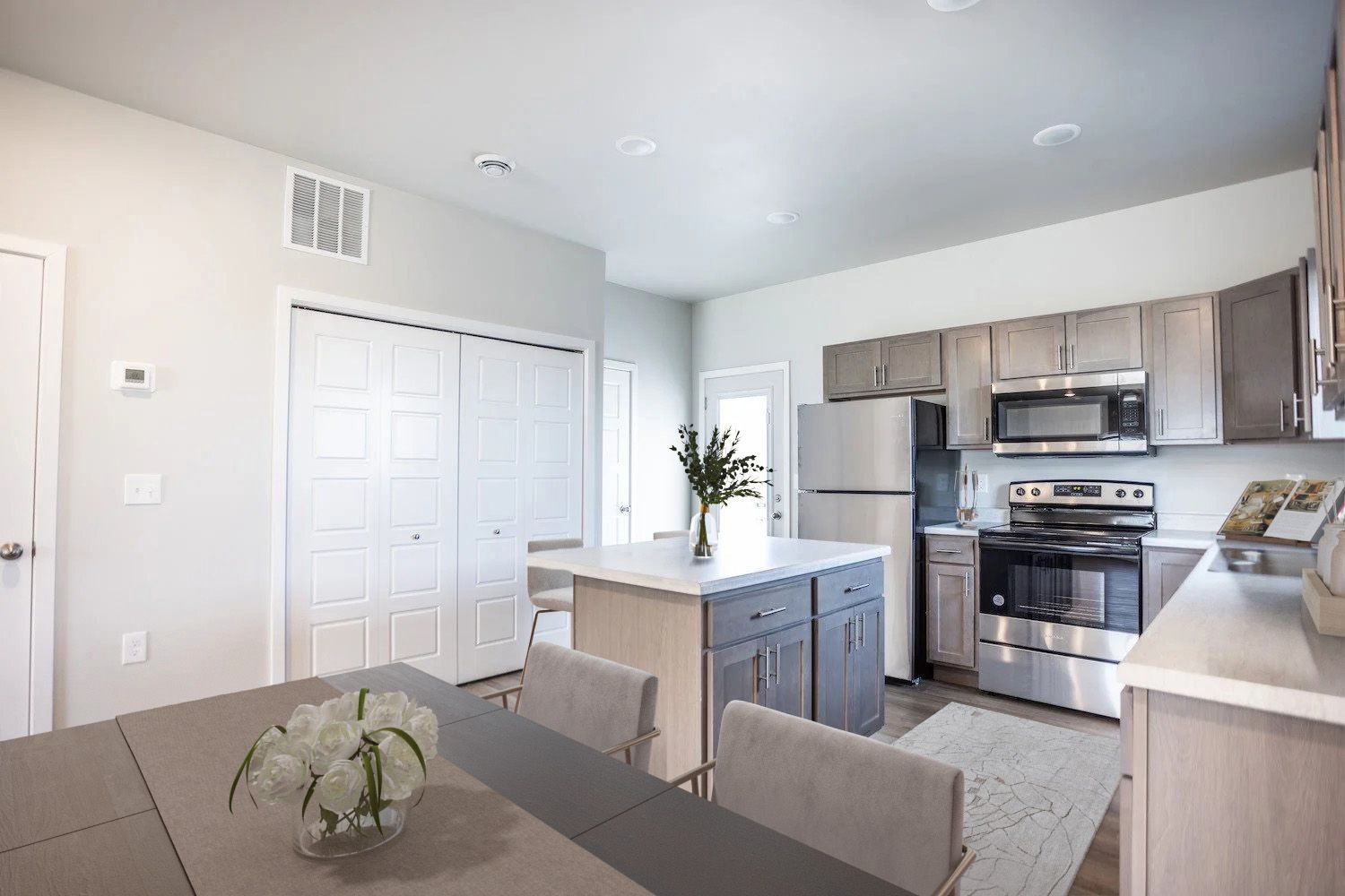 A kitchen with a table and chairs and a refrigerator.