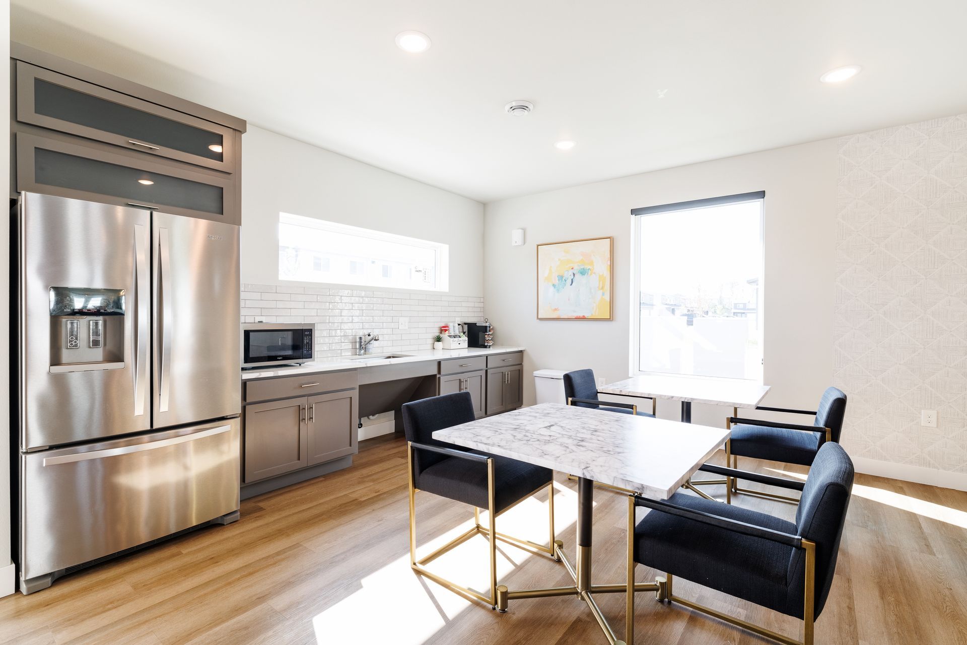 Clubhouse with fridge and tables and chairs. 