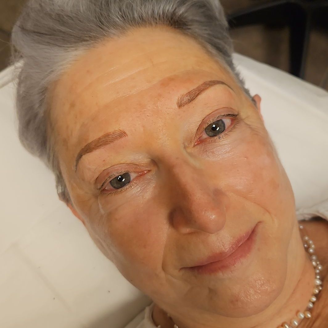 A close up of a woman 's face with gray hair and blue eyes.