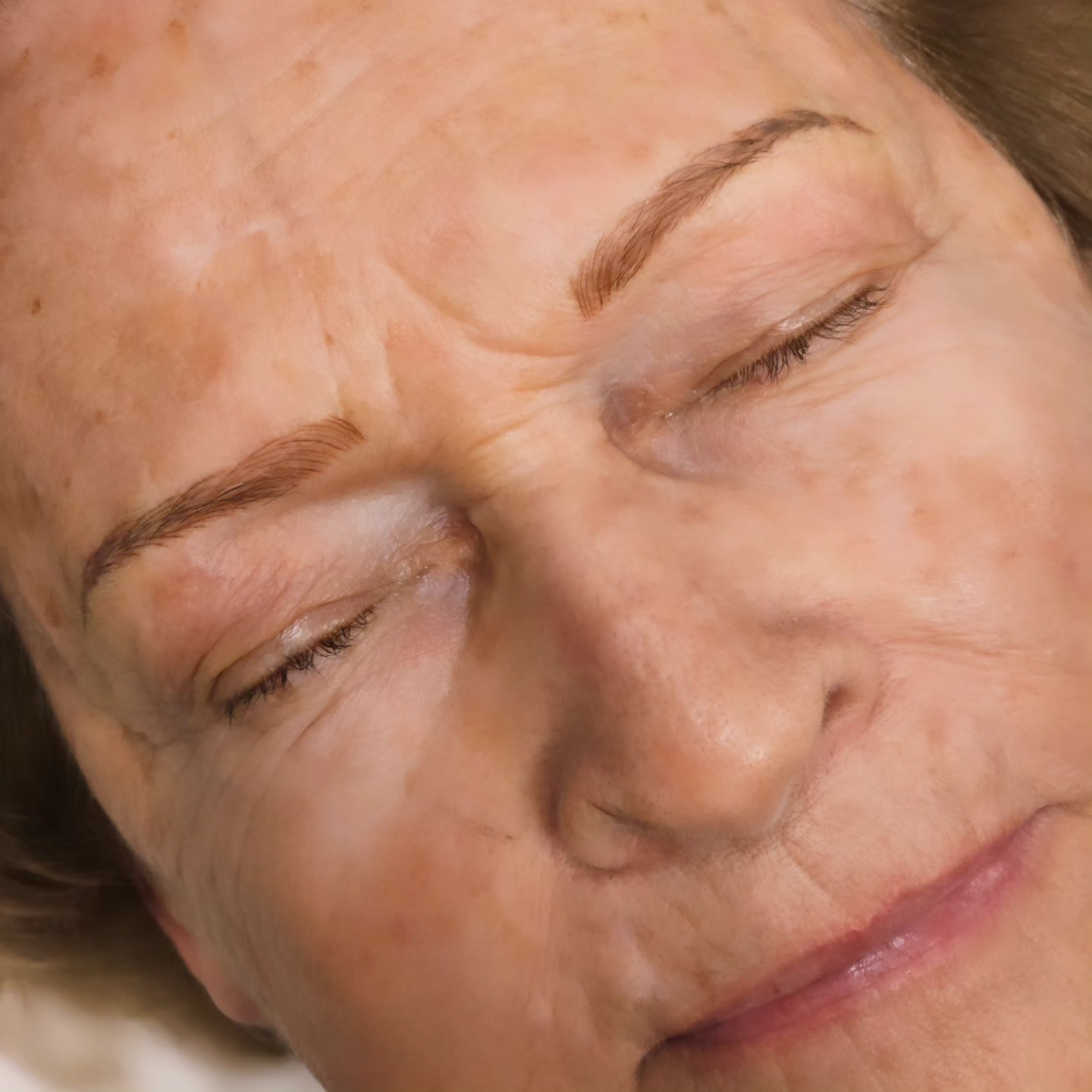 A close up of a woman 's face with her eyes closed.