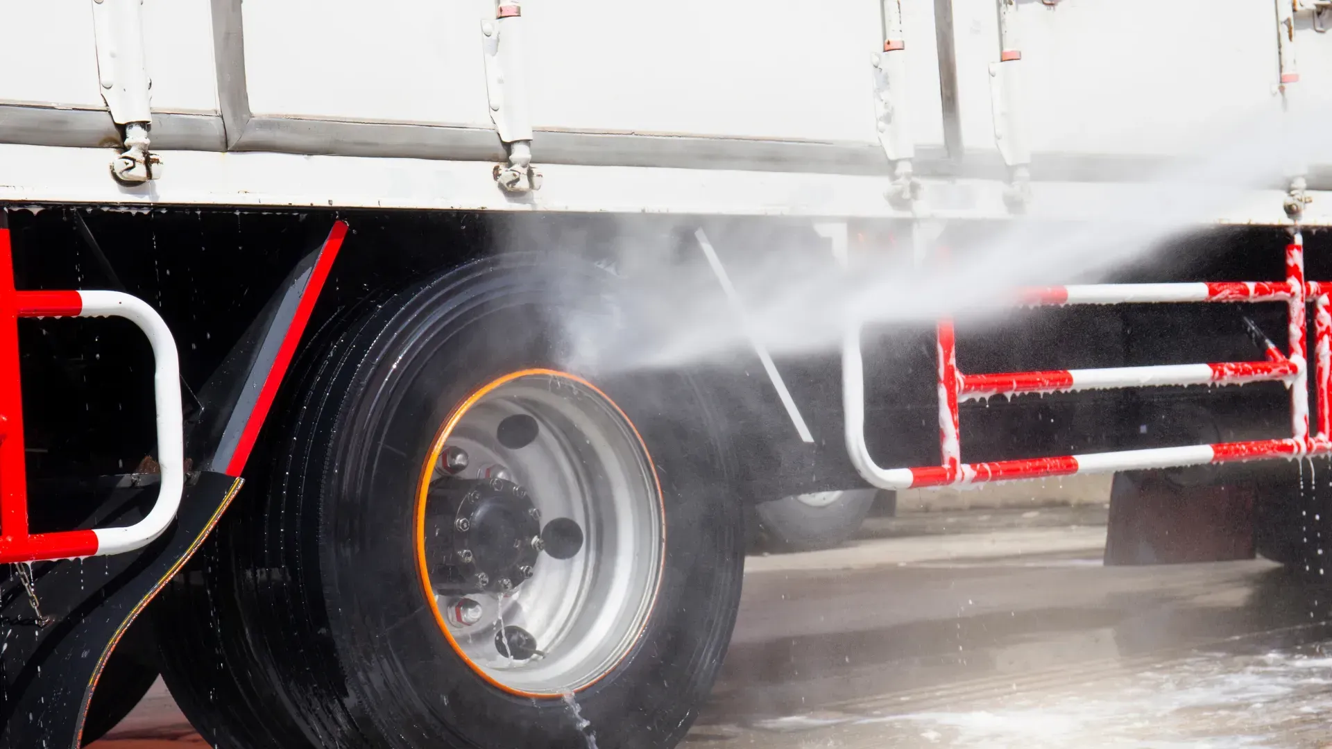 A truck is being cleaned with a high pressure washer.
