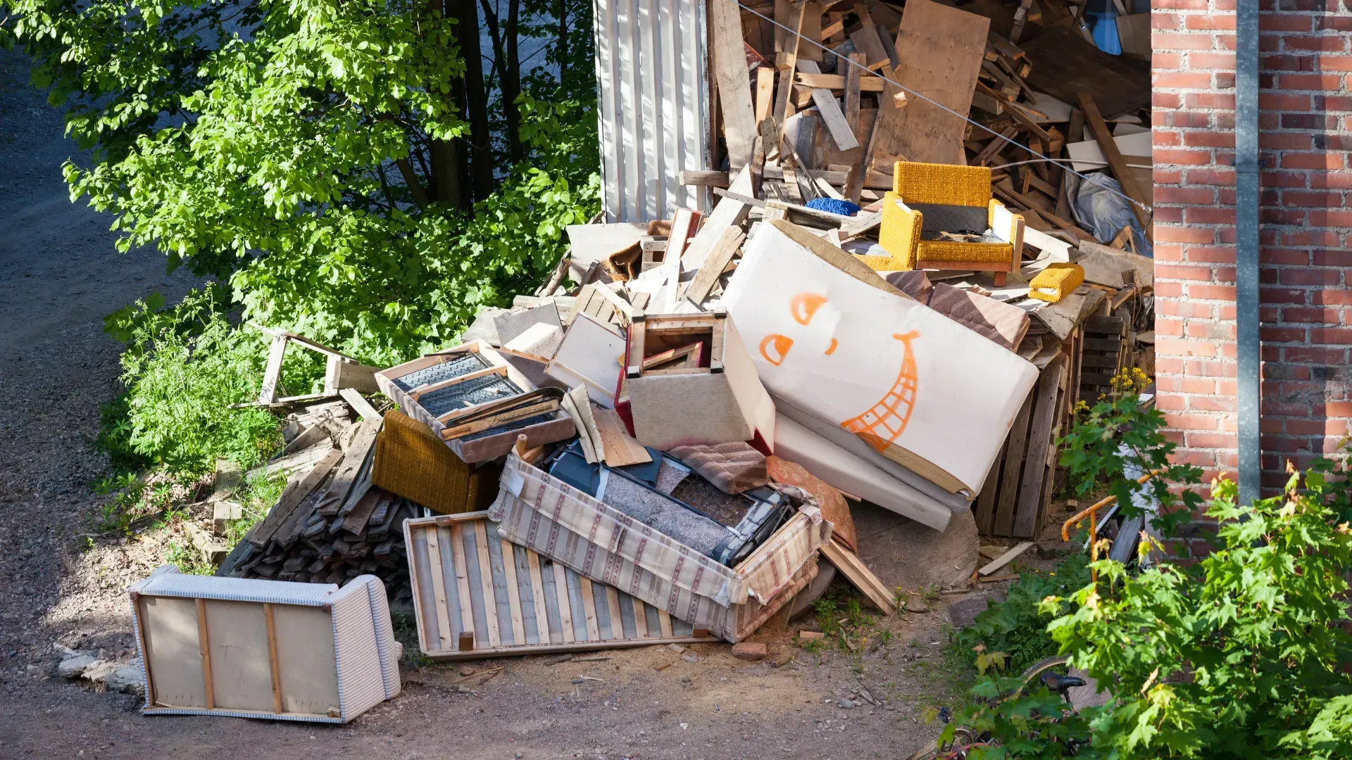 A pile of trash is sitting in front of a brick building.